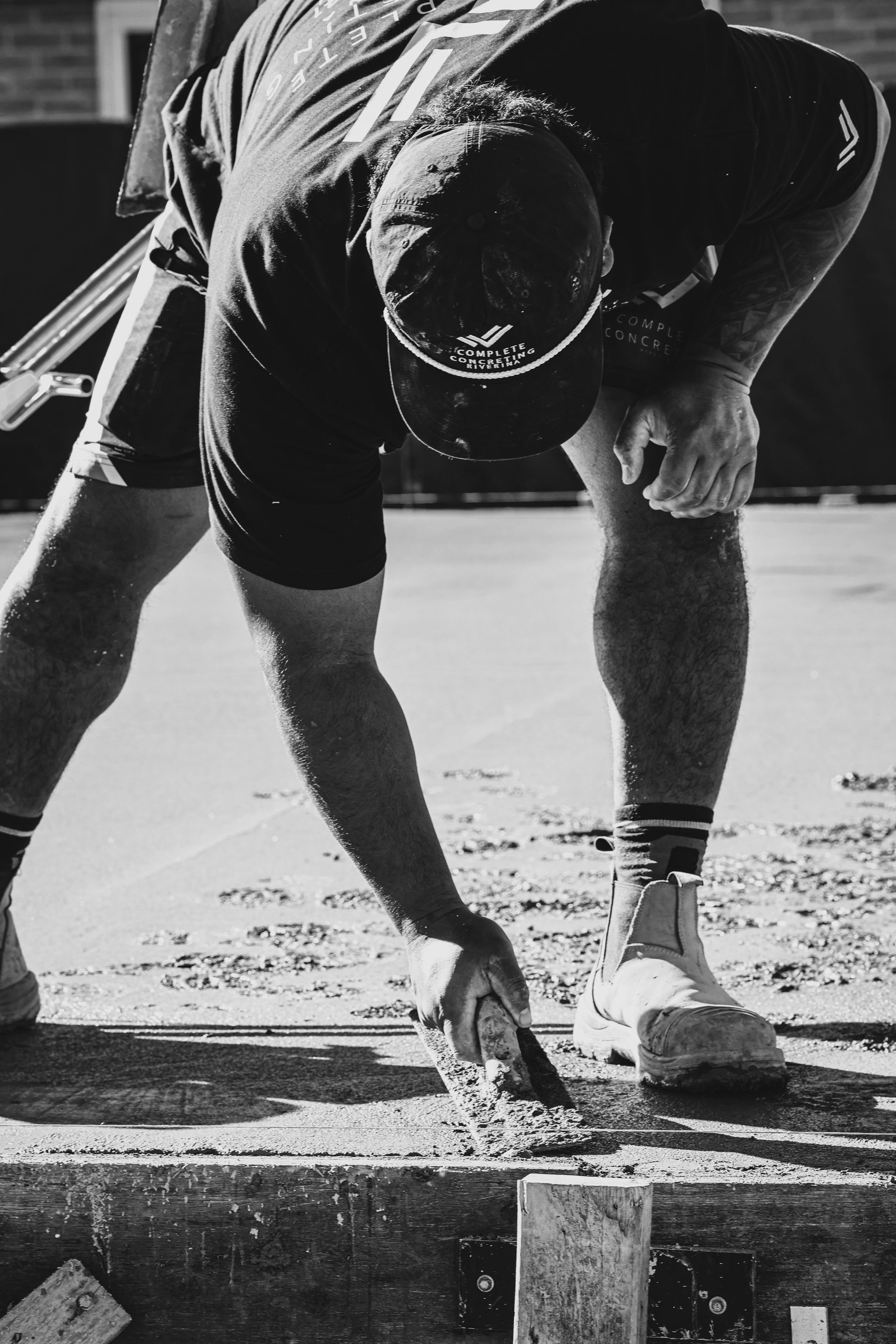 Athlete crouching at a track start line, one hand on the ground, preparing to sprint — Complete Concreting Riverina In Ashmont, NSW
