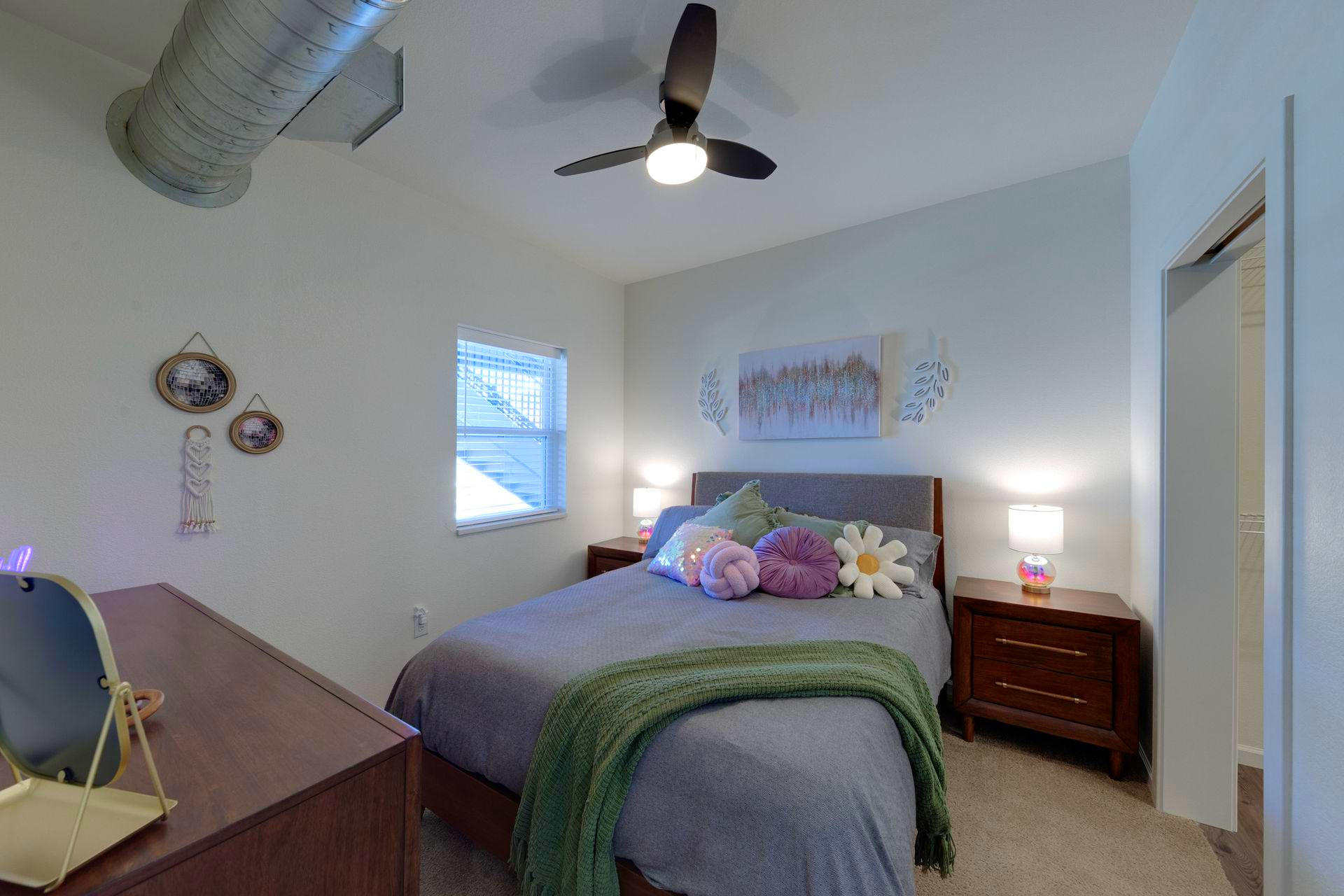 Bedroom with bed, nightstands, window, and decorative items.