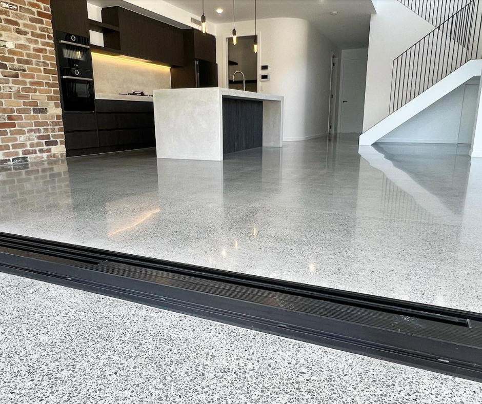 Modern kitchen and living area with polished concrete floor and white staircase. Modern kitchen and living area with polished concrete floor and white staircase.