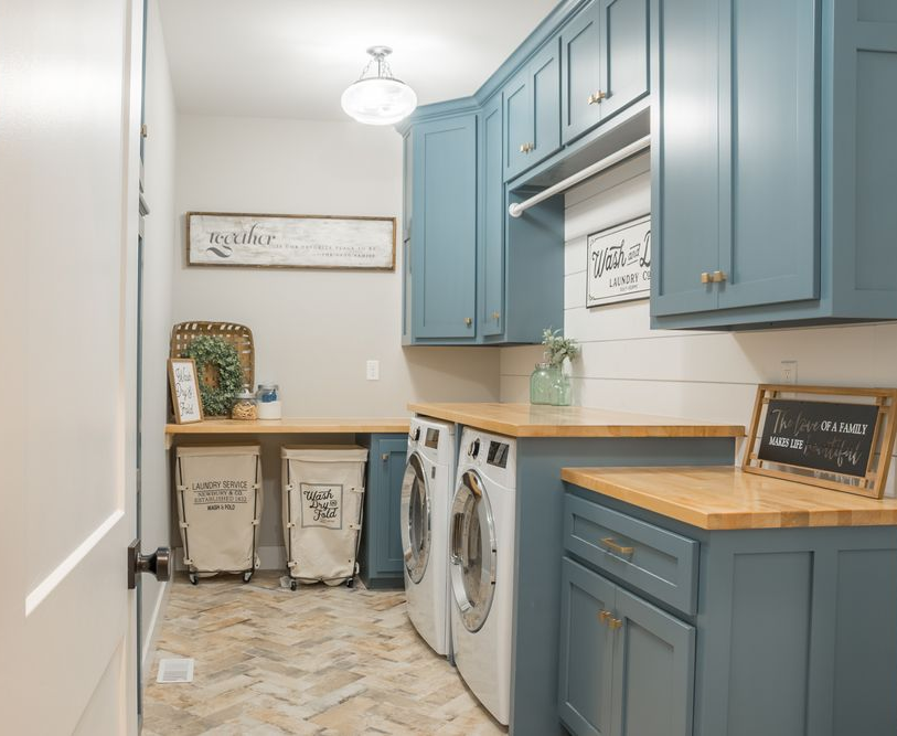 Laundry room with blue cabinets, wooden countertops, and white appliances — Norrland in Warners Bay, NSW