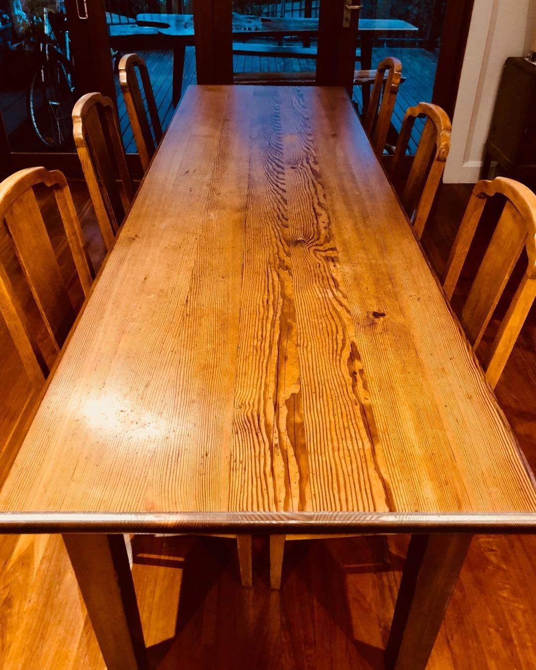 A light wood dining table with six matching chairs in a sunlit room featuring hardwood floors — Norrland in Warners Bay, NSW