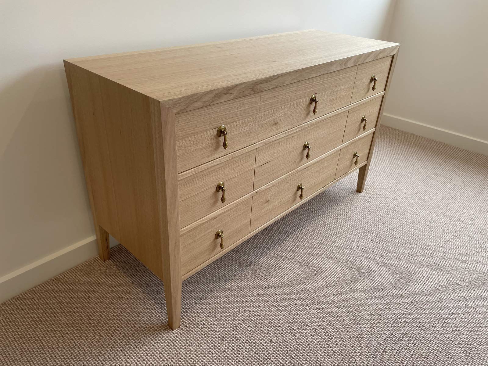 Wooden Dresser With Nine Drawers and Gold-coloured Handles, Against a White Wall — Norrland in Warners Bay, NSW