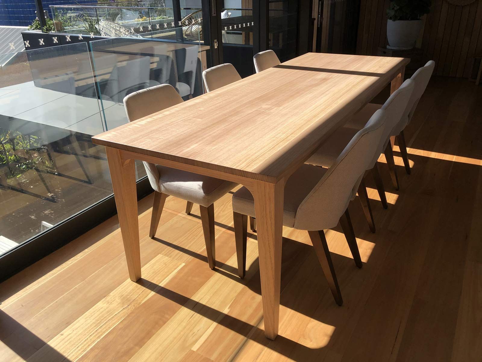 Wooden Dining Table With Eight Beige Upholstered Chairs — Norrland in Warners Bay, NSW