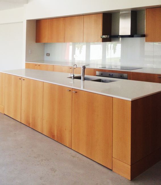 Modern Kitchen With Light Wood Cabinetry, White Countertops, and Stainless Steel Range Hood — Norrland in Warners Bay, NSW