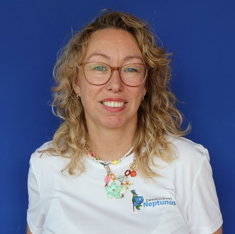 Lachende vrouw met krullend haar en een bril, gekleed in een wit Neptunus-shirt, tegen een blauwe achtergrond.