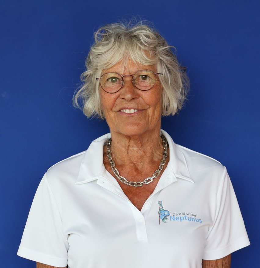 Een lachend persoon met een bril en een wit poloshirt tegen een blauwe achtergrond.