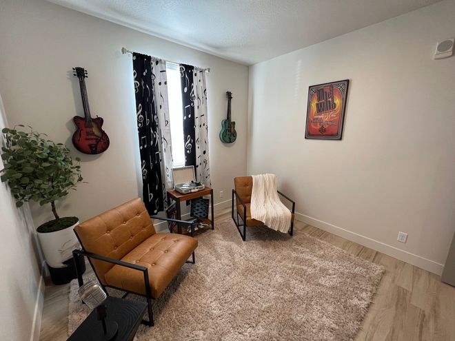 a room with two chairs and a poster that says " the world "