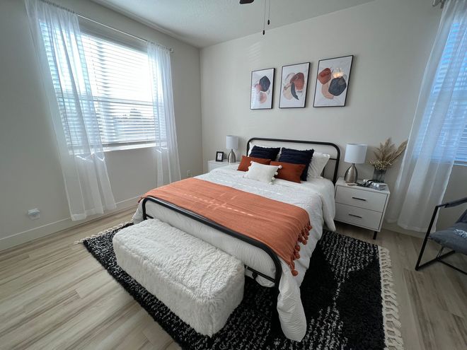 a bedroom with a bed and three paintings on the wall