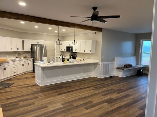 A room under construction with wood-paneled walls, white trim, a coffered ceiling, and exposed electrical wiring.