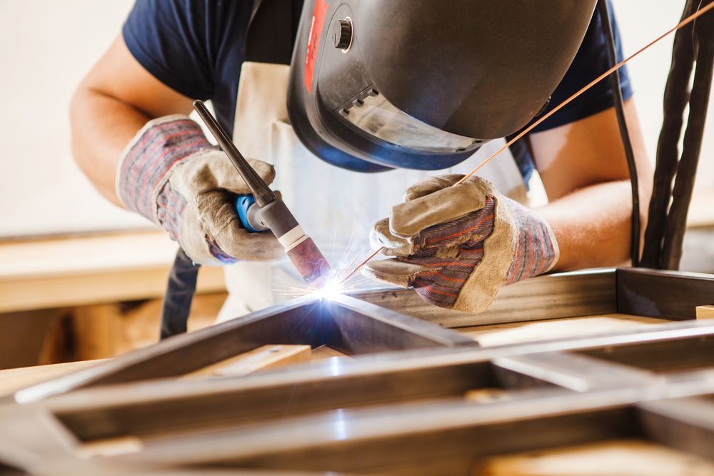 Welder Wearing Helmet and Gloves, Welding Metal Frame in Workshop — Chris Horton Manufacturing in Bathurst, NSW