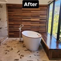 Modern bathroom with freestanding tub, wood slat accent wall, and large window seat