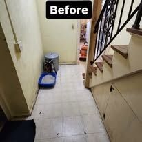 Narrow indoor hallway before cleaning, with a broom and dustpan near the stairs.