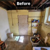 Before: unfinished basement wall with exposed patch, shelves, bucket, and supplies in a small utility room