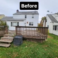 Before view of a white house with a raised wooden deck and steps in the backyard