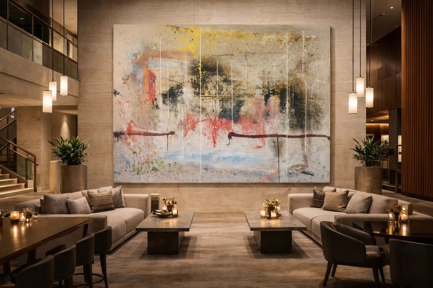 Luxurious hotel lounge with beige sofas, warm lighting, and a large abstract painting on the wall