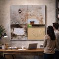 Two people view abstract art above a wooden desk in a modern office