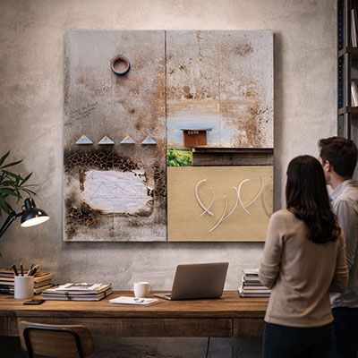 Two people view abstract art above a wooden desk in a modern office