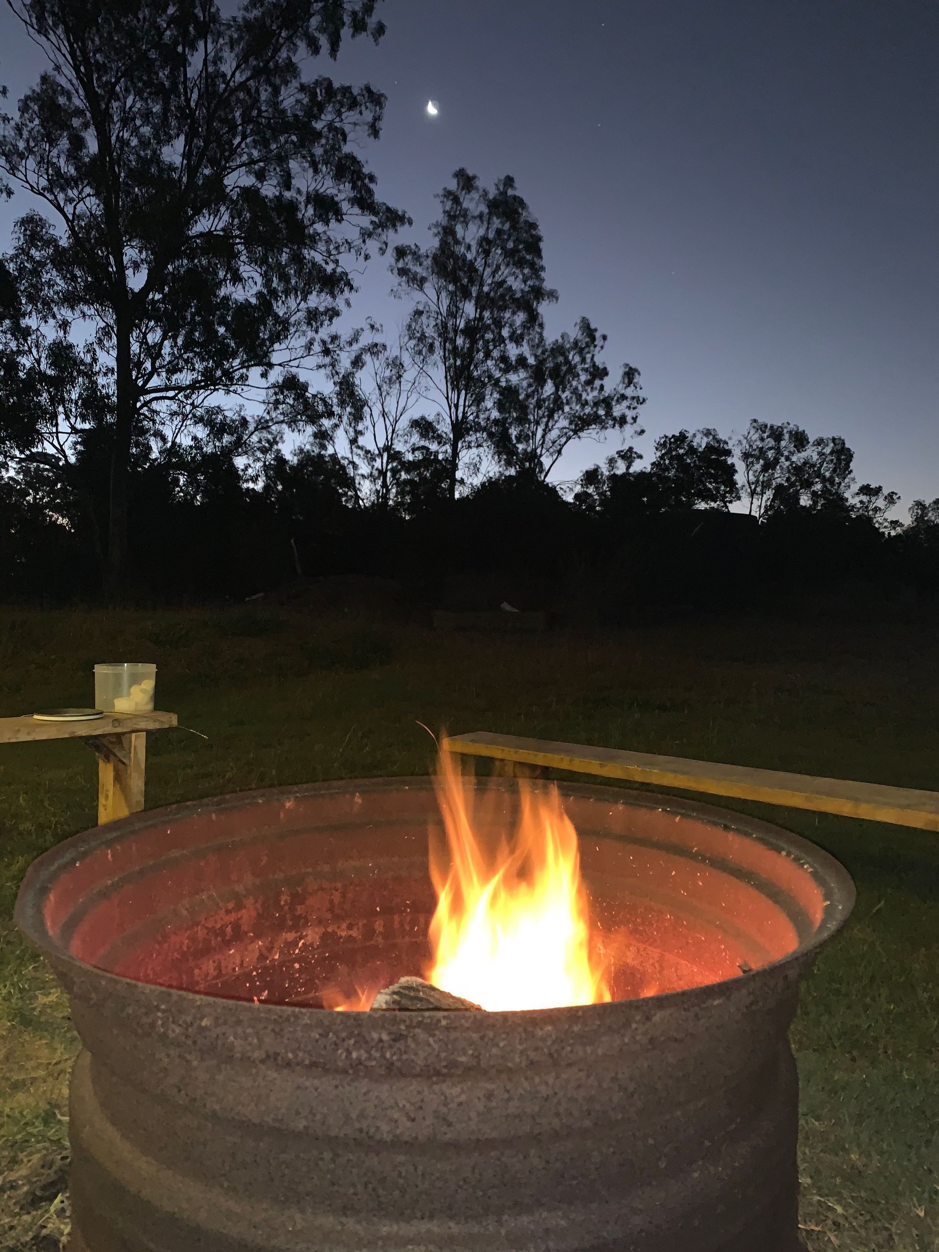 Fire Burning Brightly in a Metal Fire Pit Outdoors at Dusk — Boundary Creek Timber in Wallaville, QL