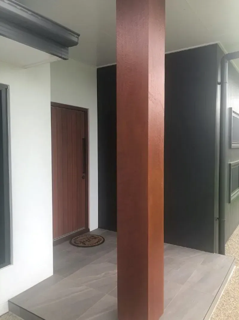 Entrance with a brown rectangular pillar, a brown door, and a dark gray wall — Boundary Creek Timber in Wallaville, QLD