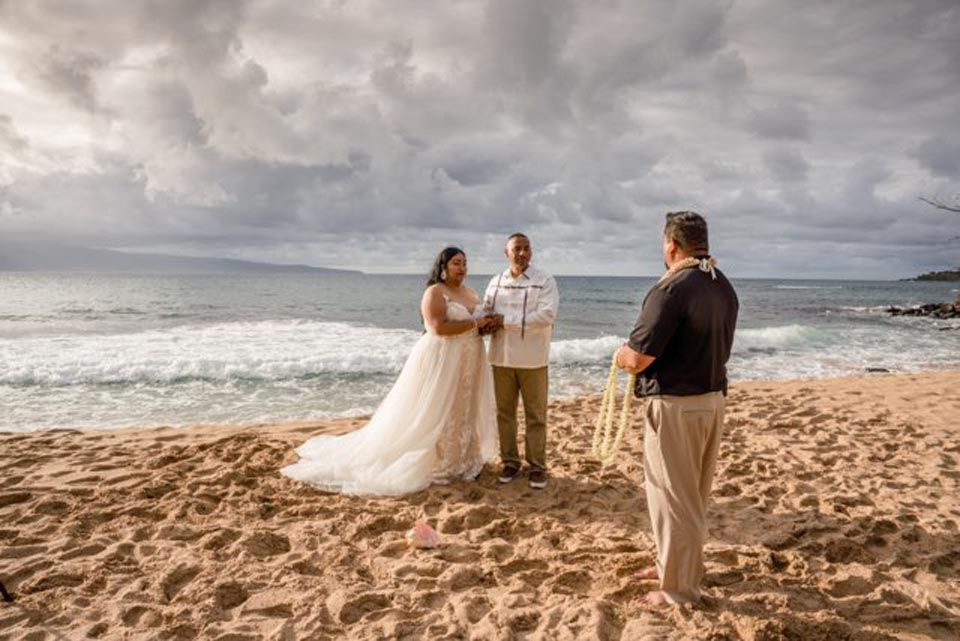 three people standing on beach