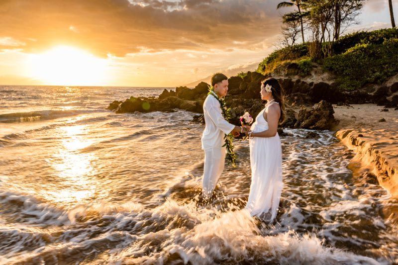 couple holding hands at sunset on beach