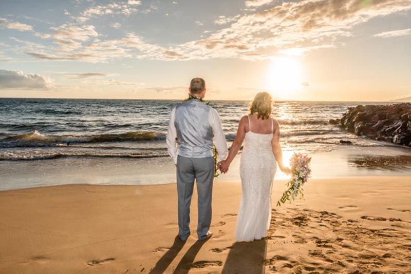 couple looking out at water during sunset
