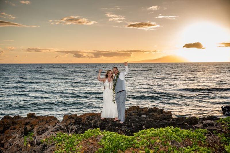 happy couple on rocks overlooking beach