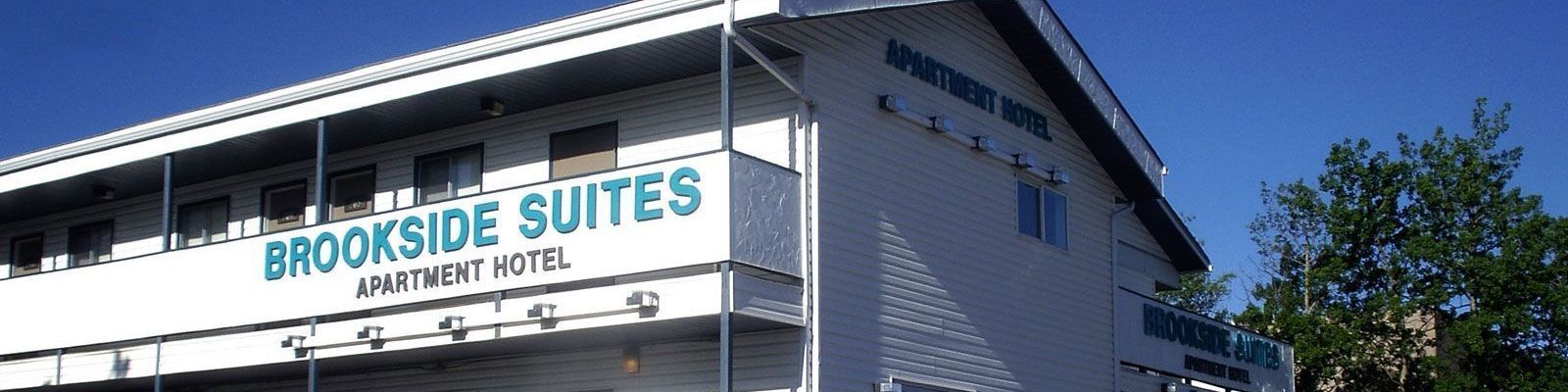 A white building with a sign that says brookside suites