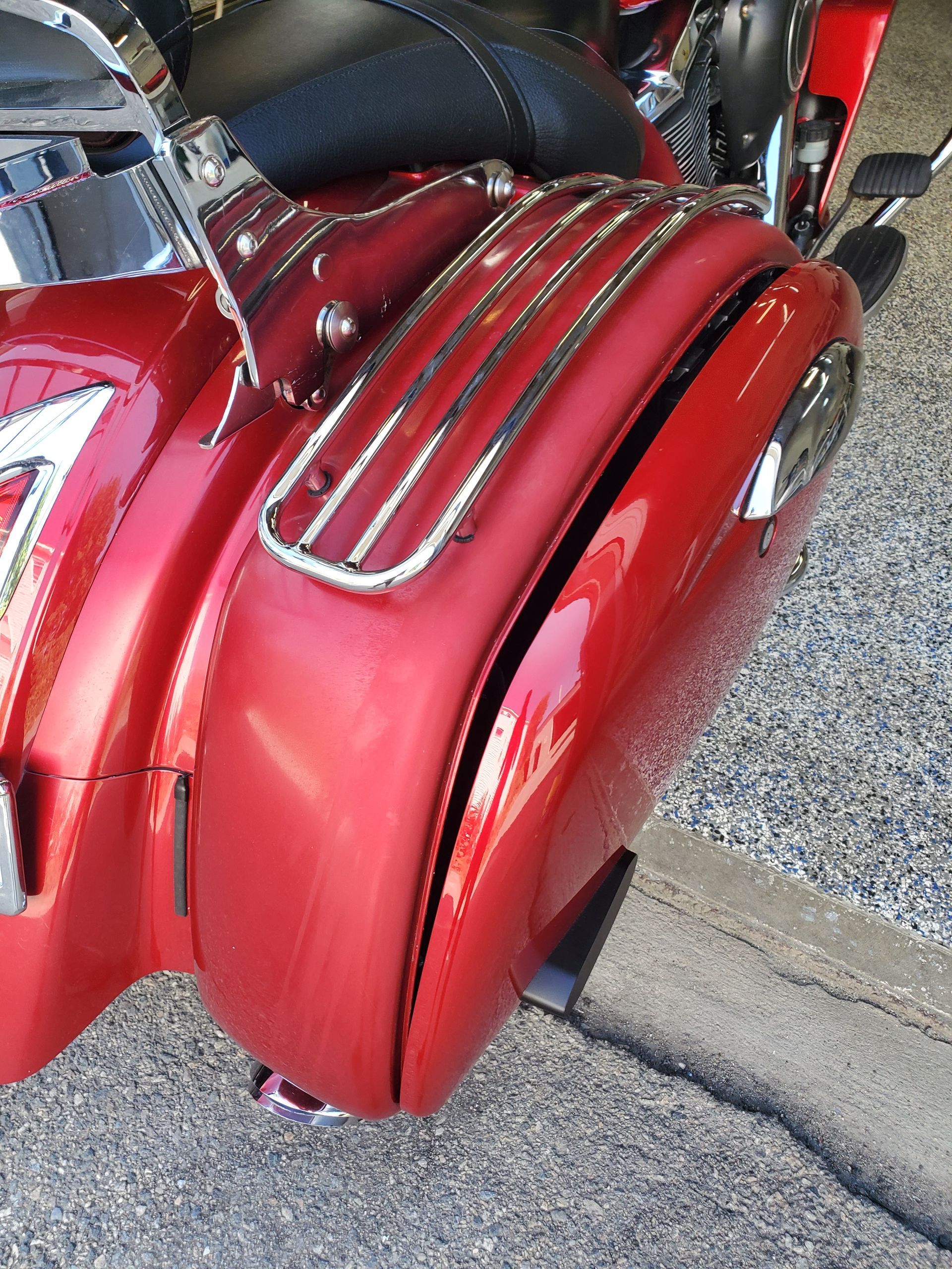A red motorcycle is parked on the side of the road