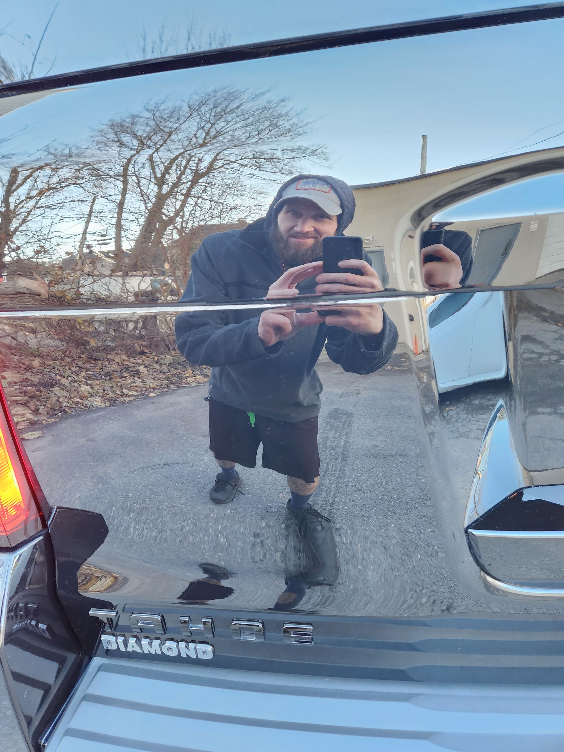 A man is taking a picture of himself in the rear view mirror of a car.