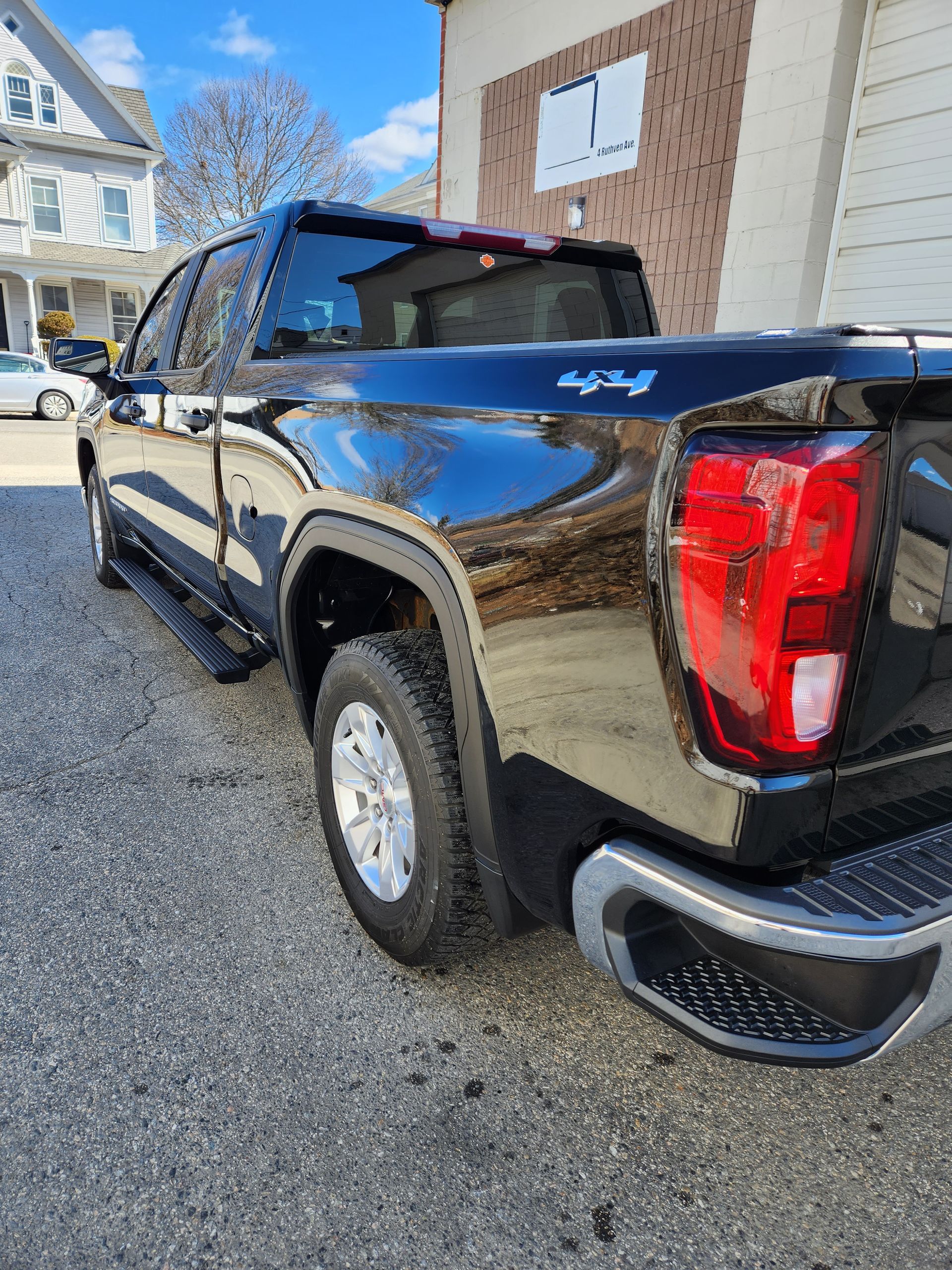 A black pickup truck is parked in front of a building.