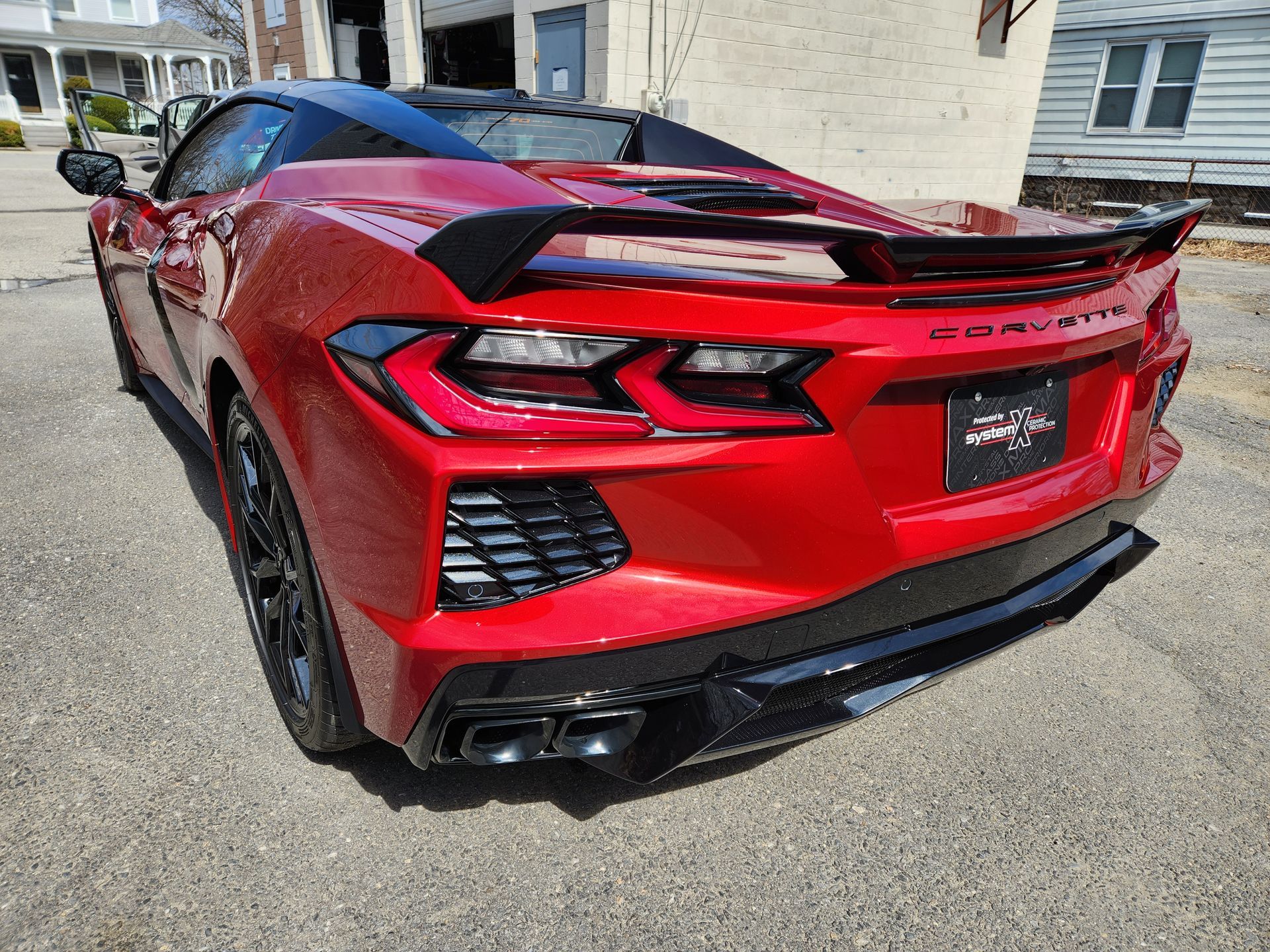 A red sports car is parked in front of a building.