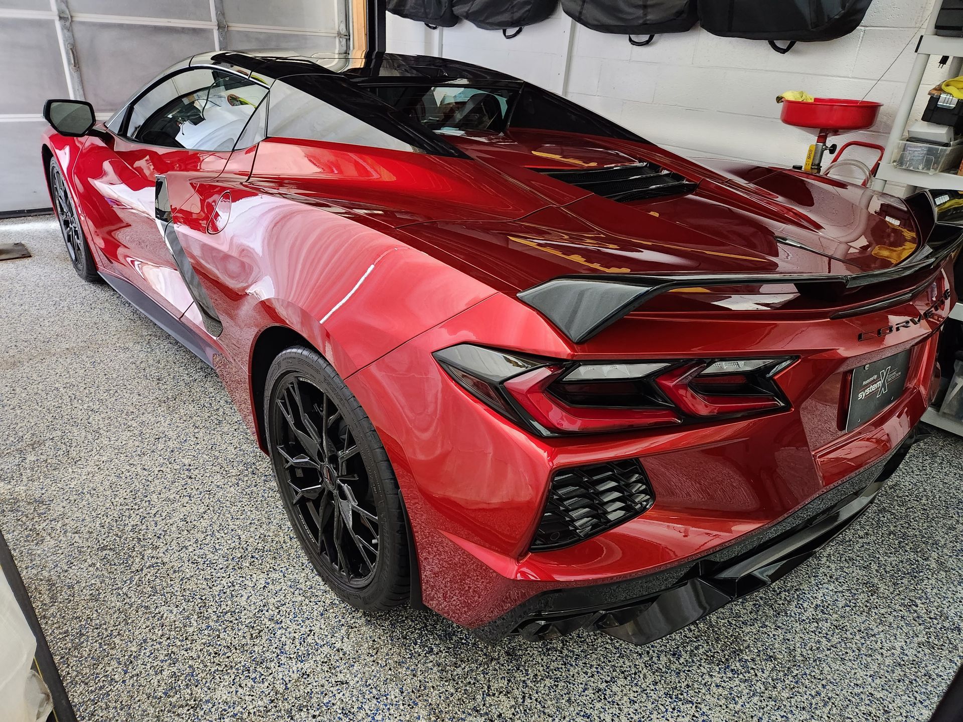 A red sports car is parked in a garage.