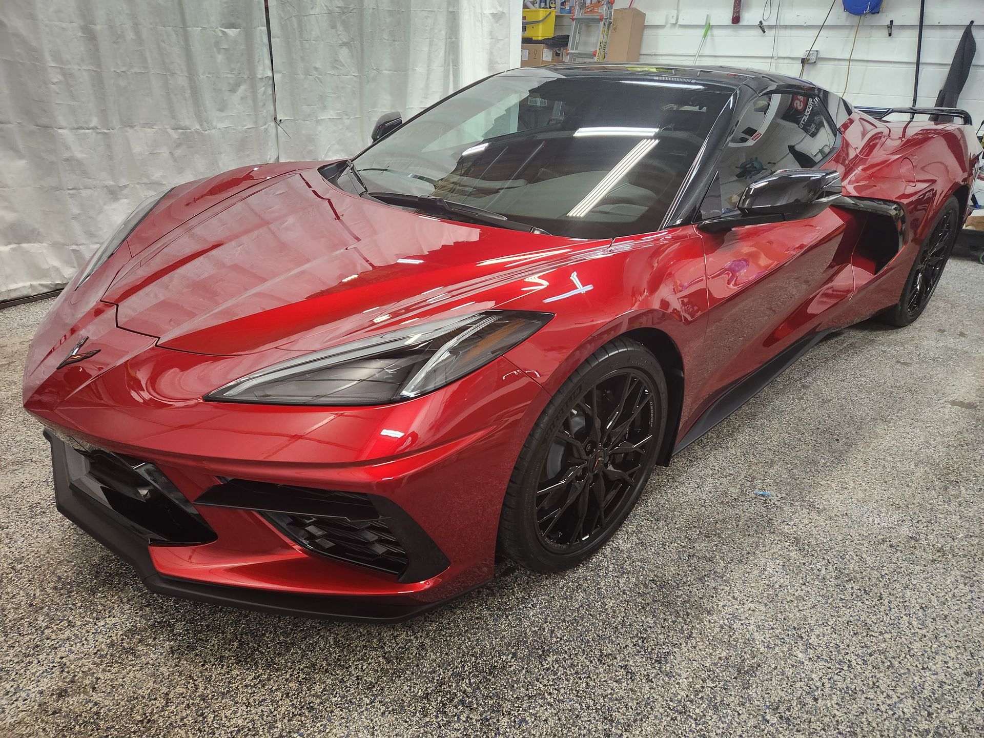 A red sports car is parked in a garage.
