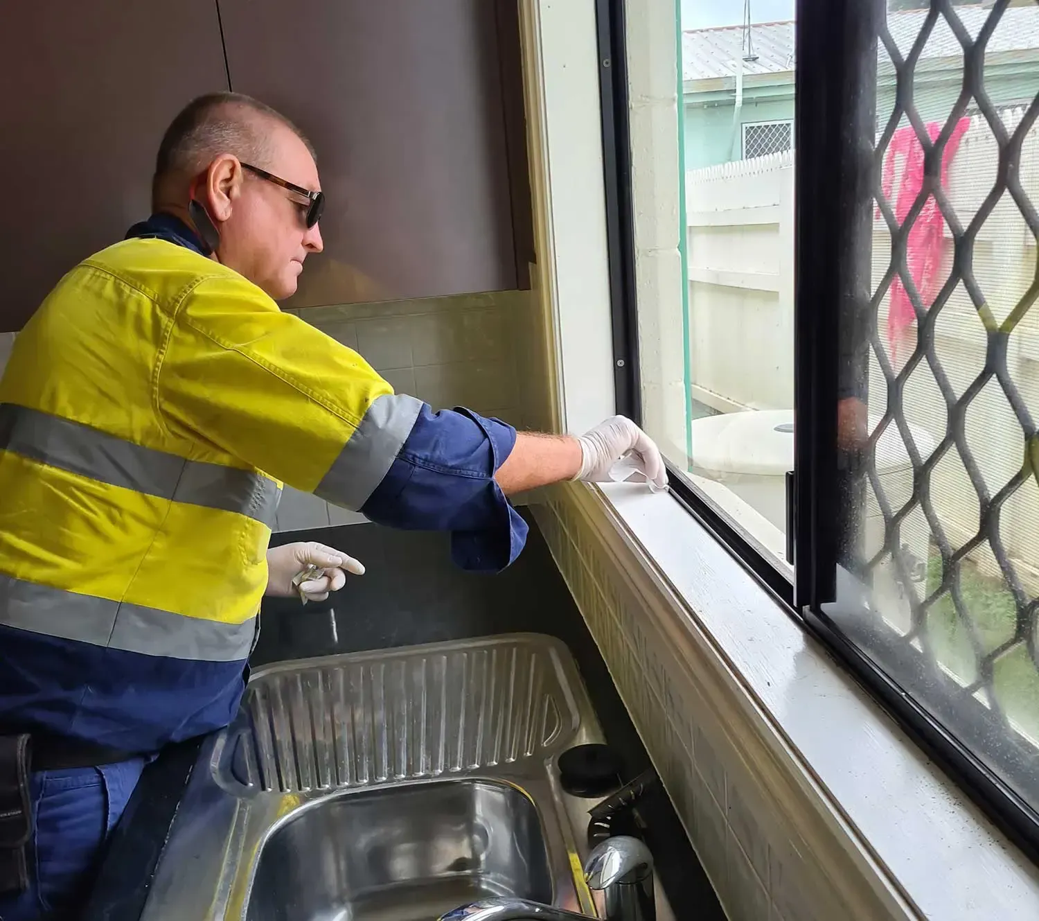 Technician cleaning window sill