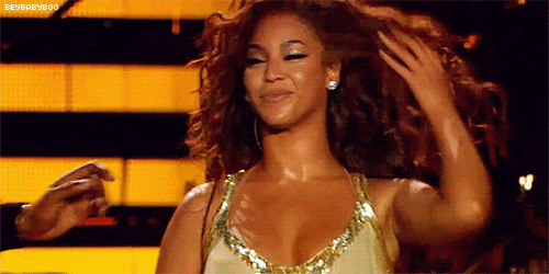 A woman is holding her hair while standing on a stage.