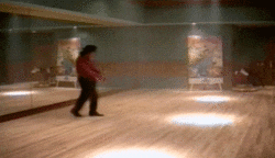 A man is dancing in a dance studio in front of a mirror.