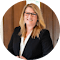 A woman wearing glasses and a black jacket is standing in a circle.