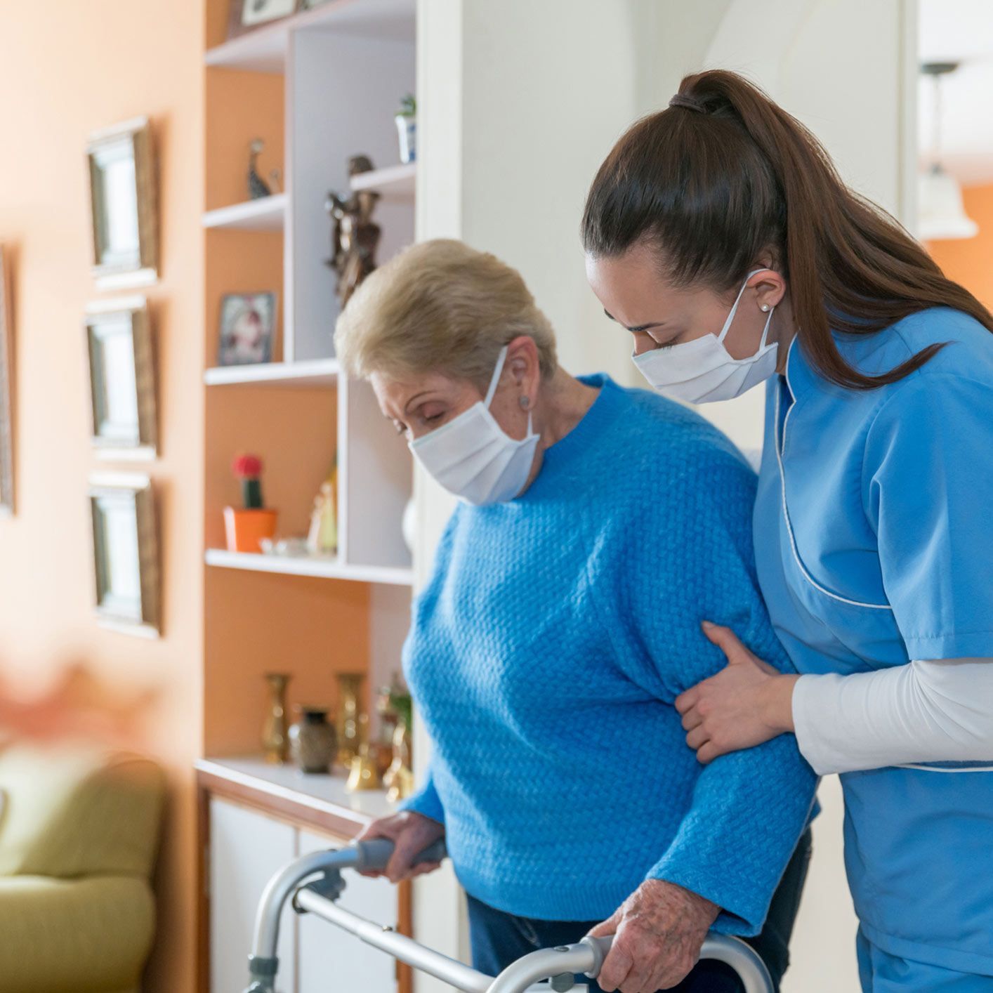 Home Caregiver Wearing A Facemask While Assisting A Senior Woman Walking With A Mobility Walker — Brooklyn, NY — Tradition Homecare