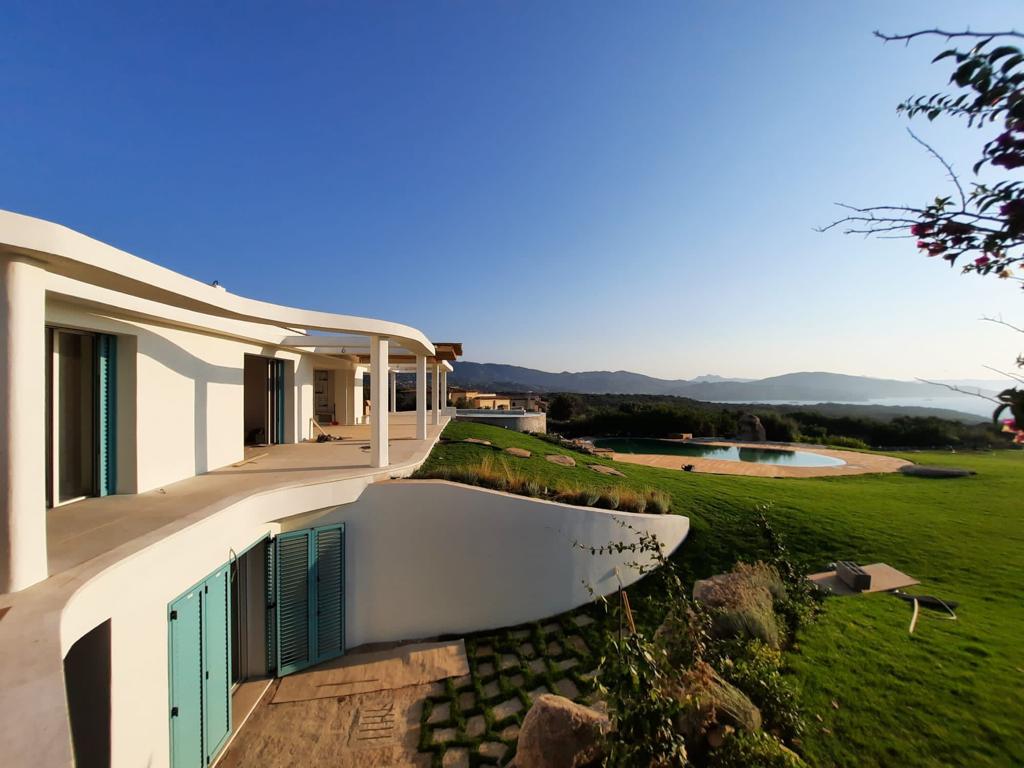 Una grande casa bianca con le persiane blu alle finestre