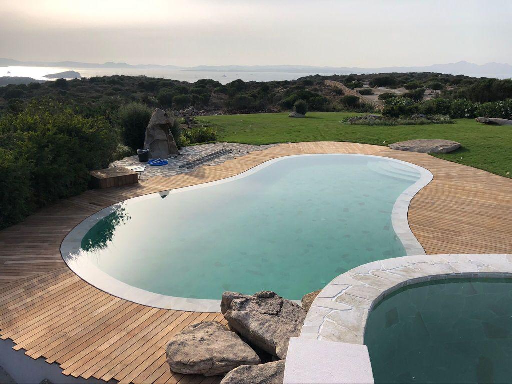 Una grande piscina con terrazza in legno e vista sull'oceano