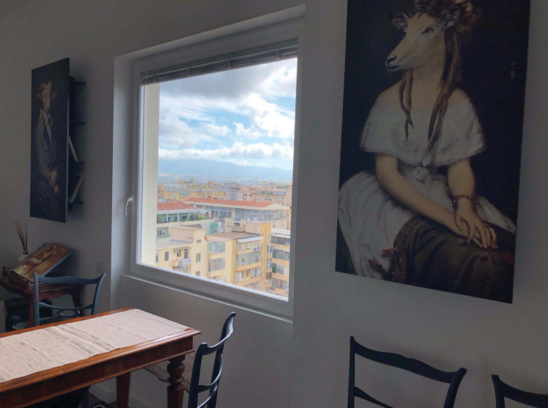 Una stanza con tavolo e sedie e un quadro sul muro.
