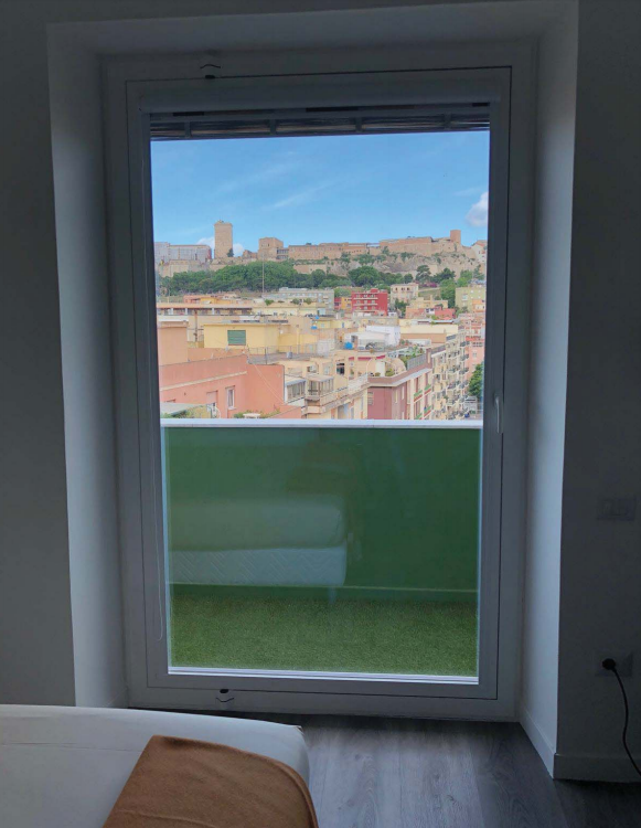 Una camera da letto con vista su una città attraverso una finestra