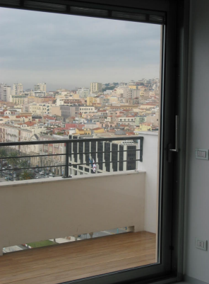 Una vista di una città da un balcone con una porta scorrevole in vetro