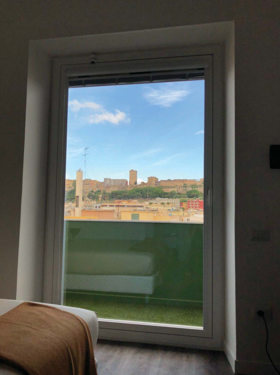 Una camera da letto con vista su una città attraverso una finestra