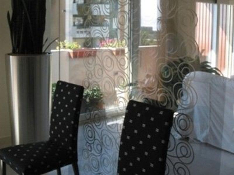 Due sedie sono sedute davanti a una porta a vetri in un soggiorno.