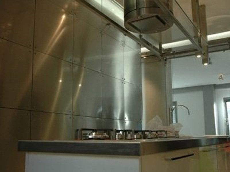 Una cucina con elettrodomestici in acciaio inox e lavello