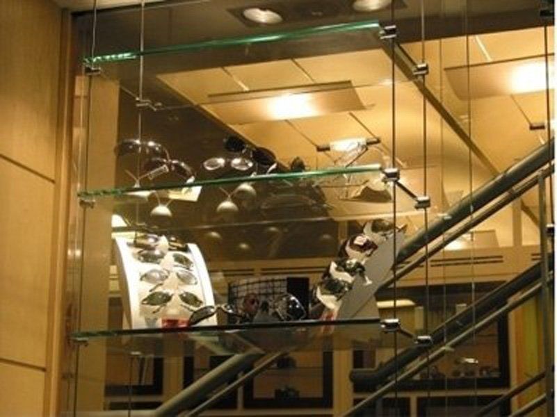 Uno scaffale di vetro con occhiali da sole in un negozio