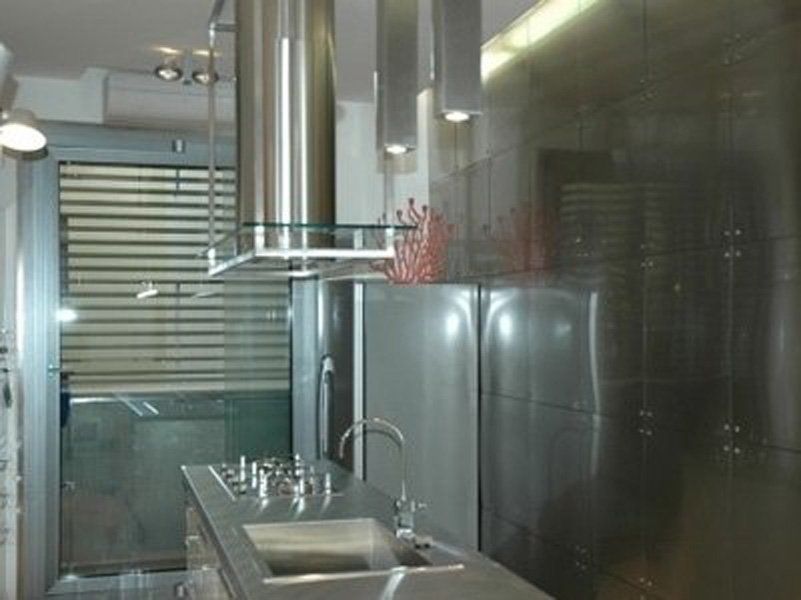 Una cucina con elettrodomestici in acciaio inox e lavello