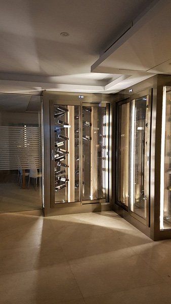 Una stanza con molte porte di vetro e molte bottiglie dentro